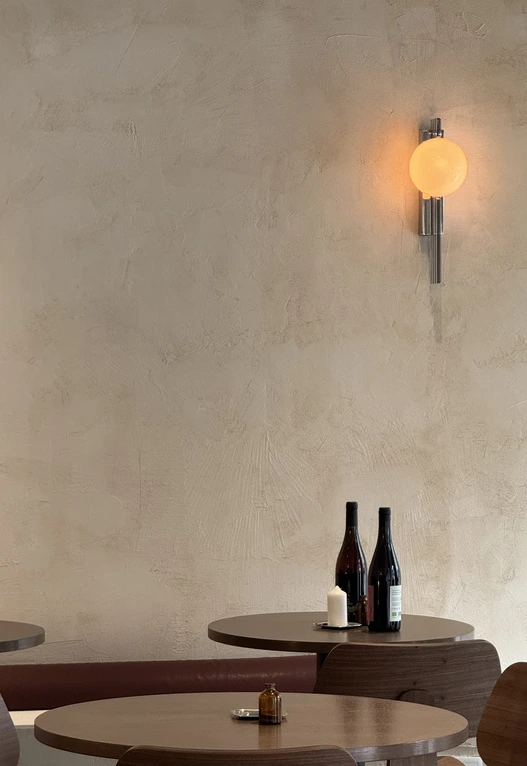 Vela acesa junto a garrafas de vinho