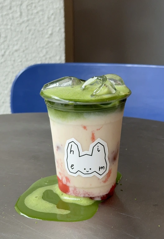 Bebida matcha em copo com desenho de gato
